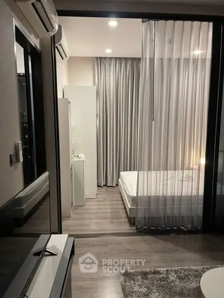 Modern bedroom with sleek design and floor-to-ceiling curtains in a stylish apartment.