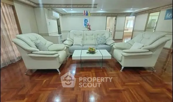 Spacious living room with elegant white sofas and polished wooden floors