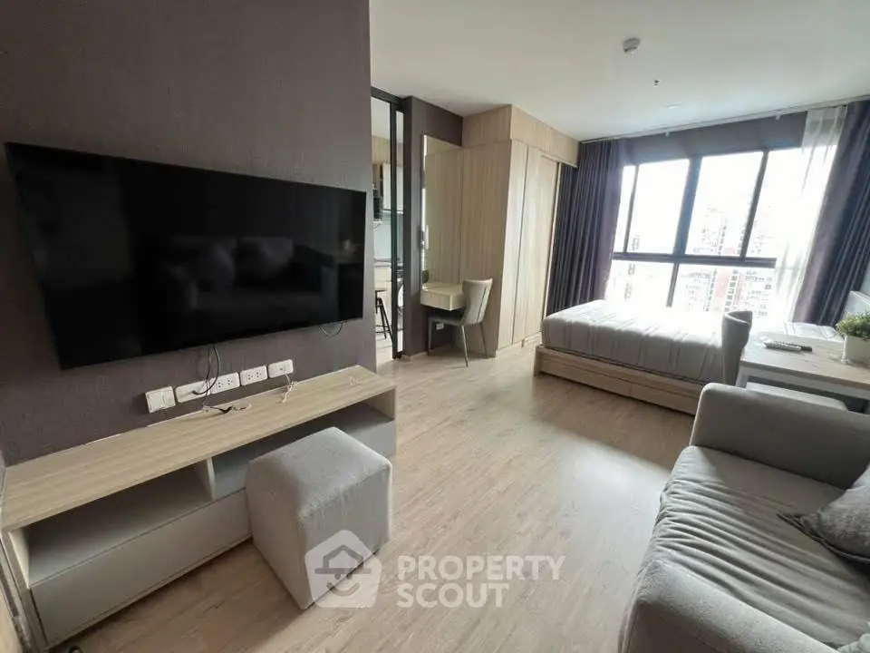 Modern studio apartment with sleek design and large windows offering city views.