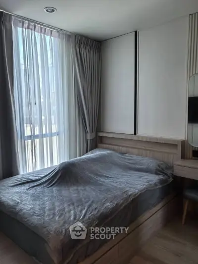 Cozy bedroom with modern design and large window for natural light