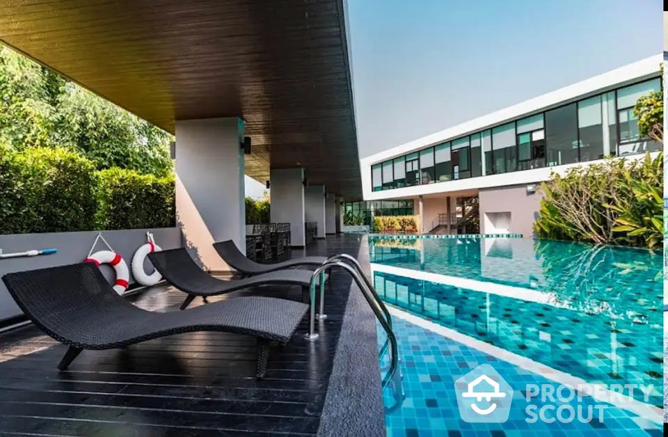 Luxurious modern poolside with sleek loungers and lush greenery, perfect for relaxation and leisure.