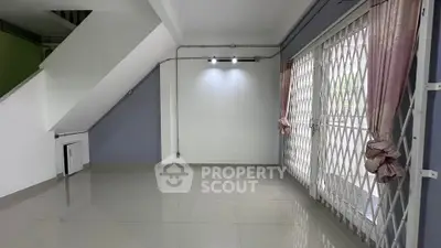 Spacious living room with large windows and modern lighting