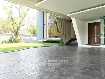 Modern home entrance with sleek design and spacious driveway