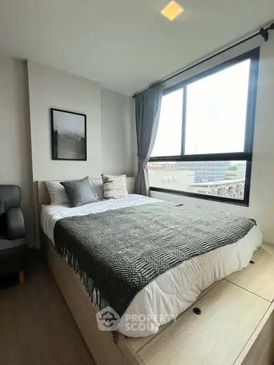 Modern bedroom with large window and stylish decor in urban apartment