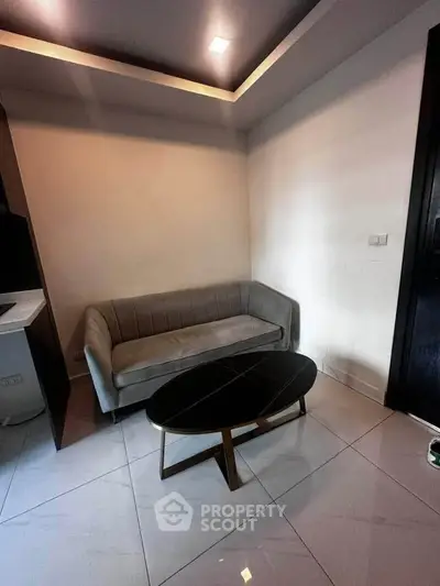 Modern living room with sleek sofa and stylish coffee table in a cozy apartment setting.