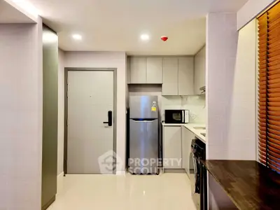 Modern kitchen with sleek appliances and stylish cabinetry in a compact layout.