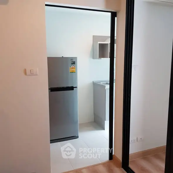 Modern kitchen with sleek fridge and minimalist design in a stylish apartment.