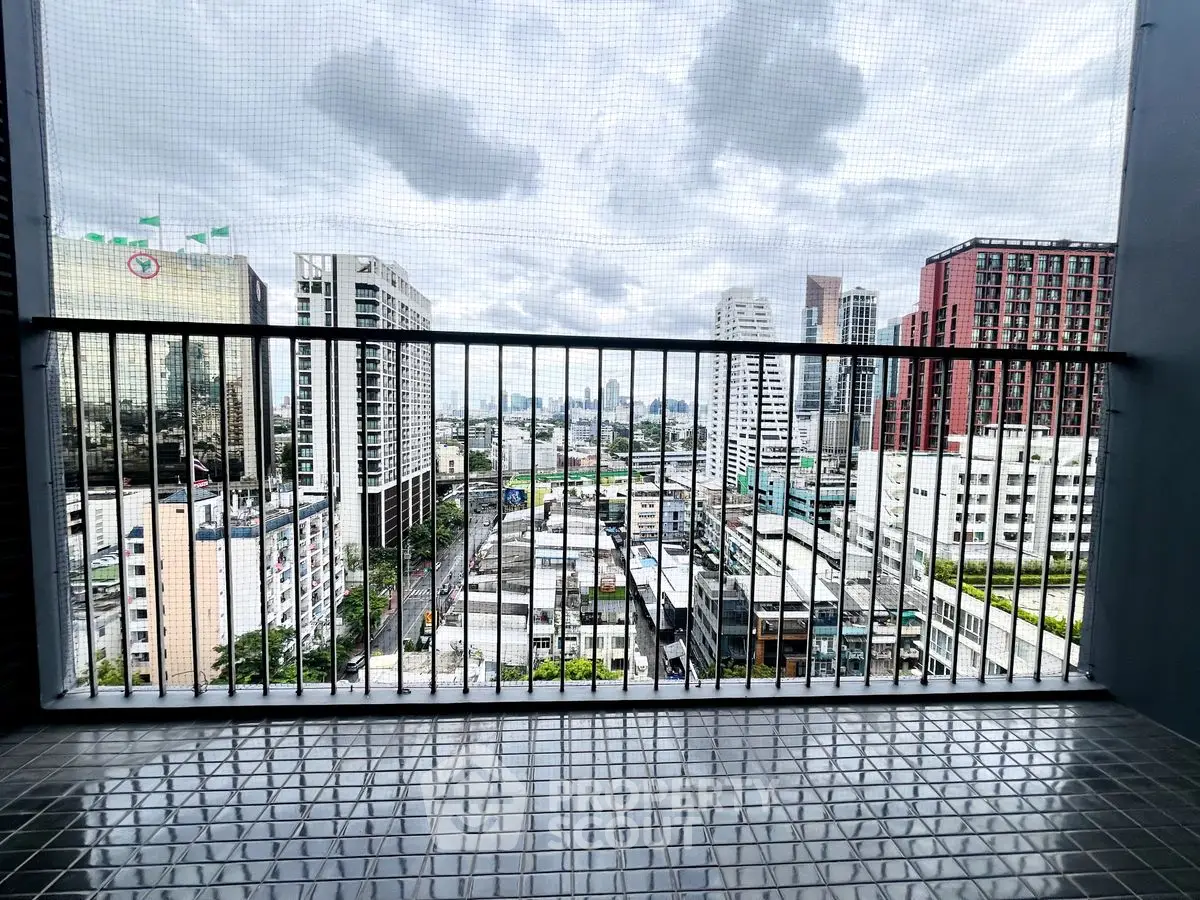 Stunning cityscape view from high-rise balcony with modern railing.