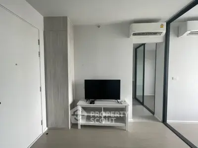 Modern minimalist living room with TV and air conditioning in sleek apartment