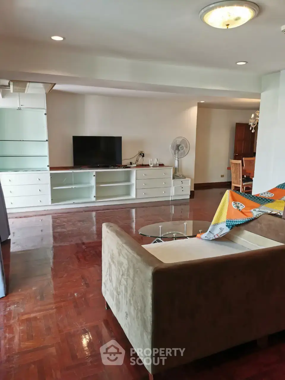 Spacious living room with modern furniture and hardwood floors in a stylish apartment.