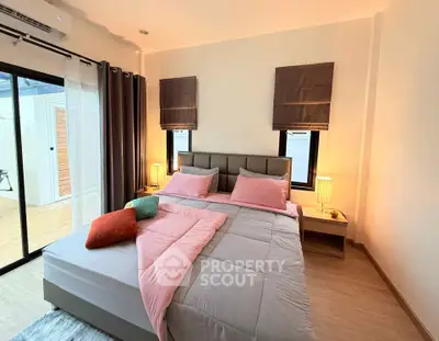 Cozy bedroom with modern decor and ample natural light, featuring a comfortable bed and stylish furnishings.