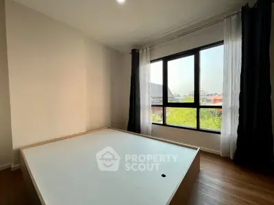 Spacious bedroom with large window offering a scenic view, perfect for natural light lovers.