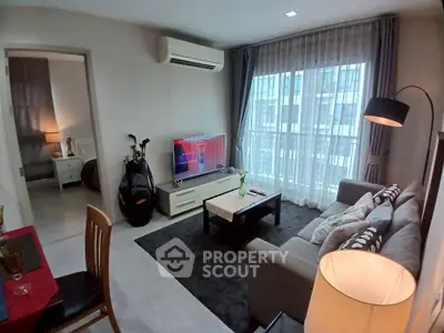 Modern living room with large window, cozy sofa, and stylish decor in urban apartment.