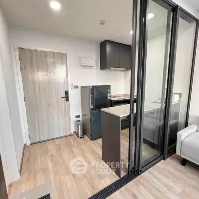 Modern compact kitchen with sliding glass doors and sleek design