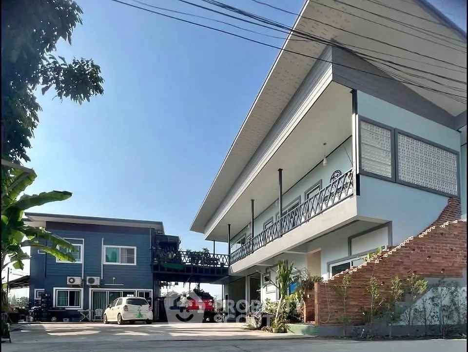 Modern two-story building with spacious parking and lush greenery