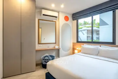 Modern bedroom with large window and stylish decor in a contemporary apartment.