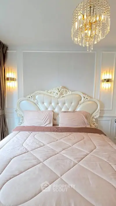 Luxurious bedroom with elegant chandelier and ornate headboard, perfect for sophisticated living.