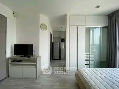 Modern bedroom with sleek design, featuring a TV, wardrobe, and large window for natural light.