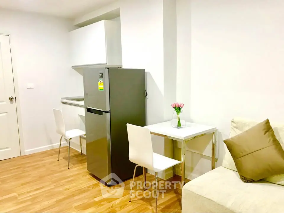 Modern compact kitchen with dining area and cozy seating in bright apartment