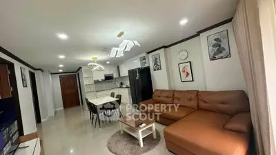 Spacious modern living room with open kitchen, stylish decor, and cozy seating area.