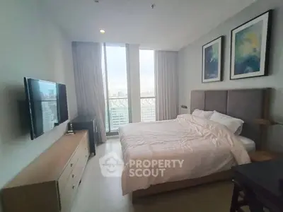 Spacious bedroom with large windows and modern decor in a high-rise apartment.