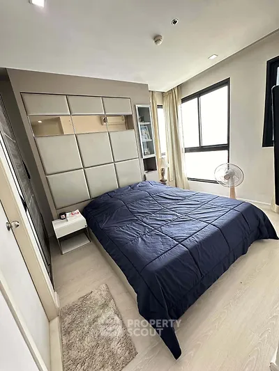 Modern bedroom with stylish decor and large windows offering natural light