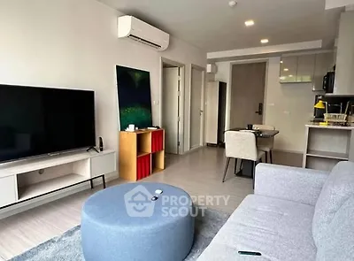 Modern living room with sleek furniture and open kitchen layout in a stylish apartment.