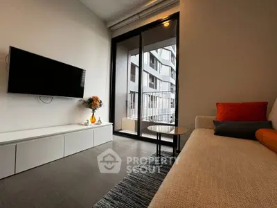 Modern living room with sleek TV setup and large window view in urban apartment.