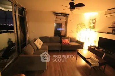 Cozy living room with sectional sofa and city view balcony at night