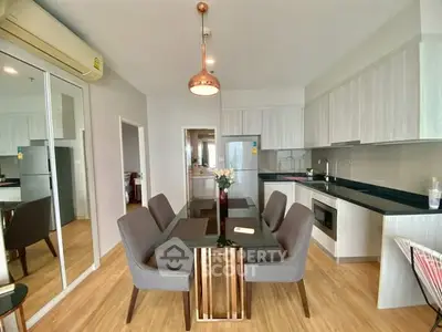 Modern dining area with sleek kitchen in open layout apartment
