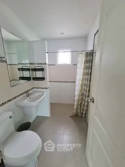 Modern bathroom with sleek fixtures and stylish shower curtain in a bright, airy space.