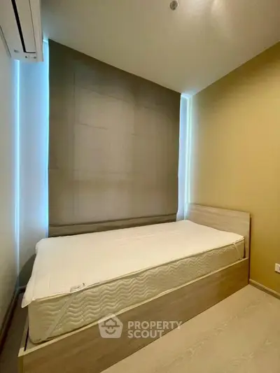 Cozy minimalist bedroom with single bed and modern air conditioning unit.