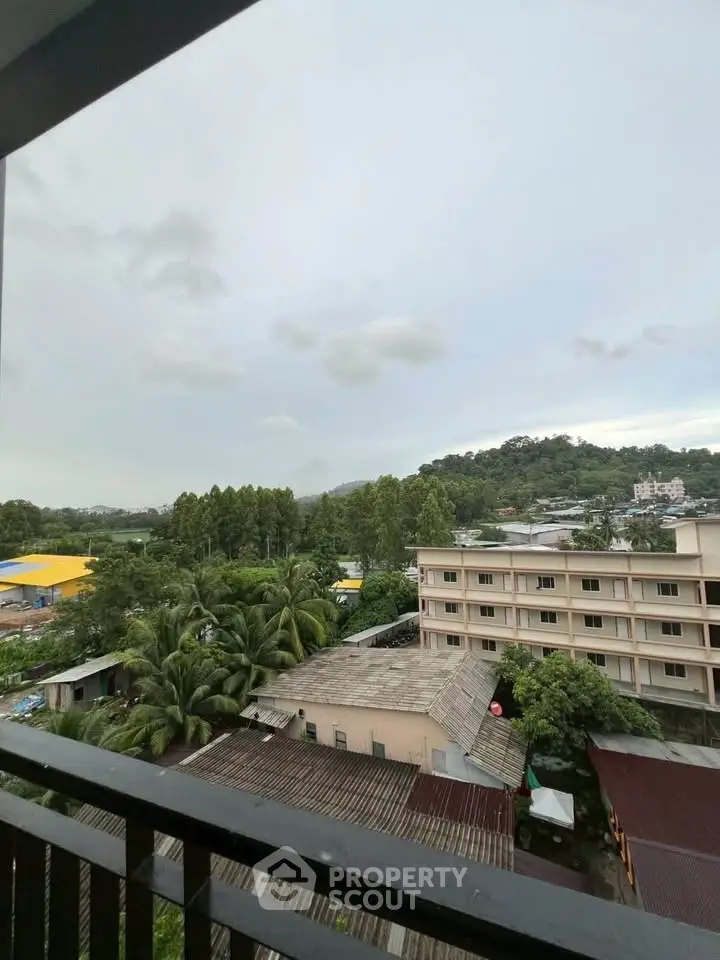 Scenic view from balcony overlooking lush greenery and distant hills, perfect for nature lovers.