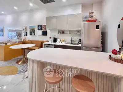 Modern kitchen with open layout and stylish dining area, featuring sleek appliances and contemporary decor.