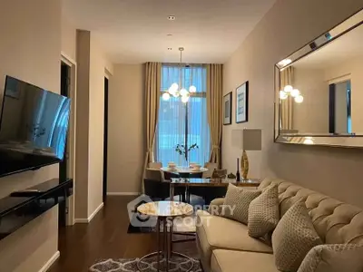 Elegant living room with modern decor, plush sofa, wall-mounted TV, and dining area with chic lighting.