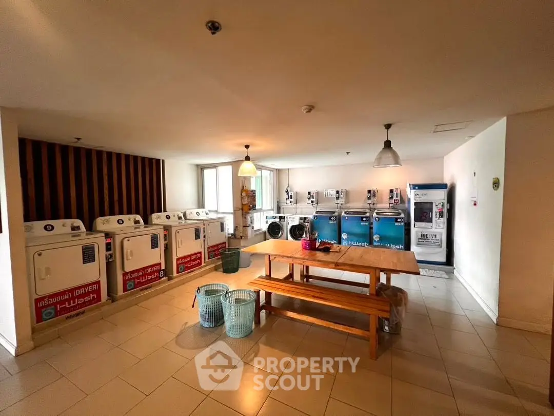 Spacious laundry room with multiple washing machines and dryers in a modern apartment building.