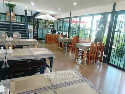 Spacious dining area with modern decor and large windows offering garden views