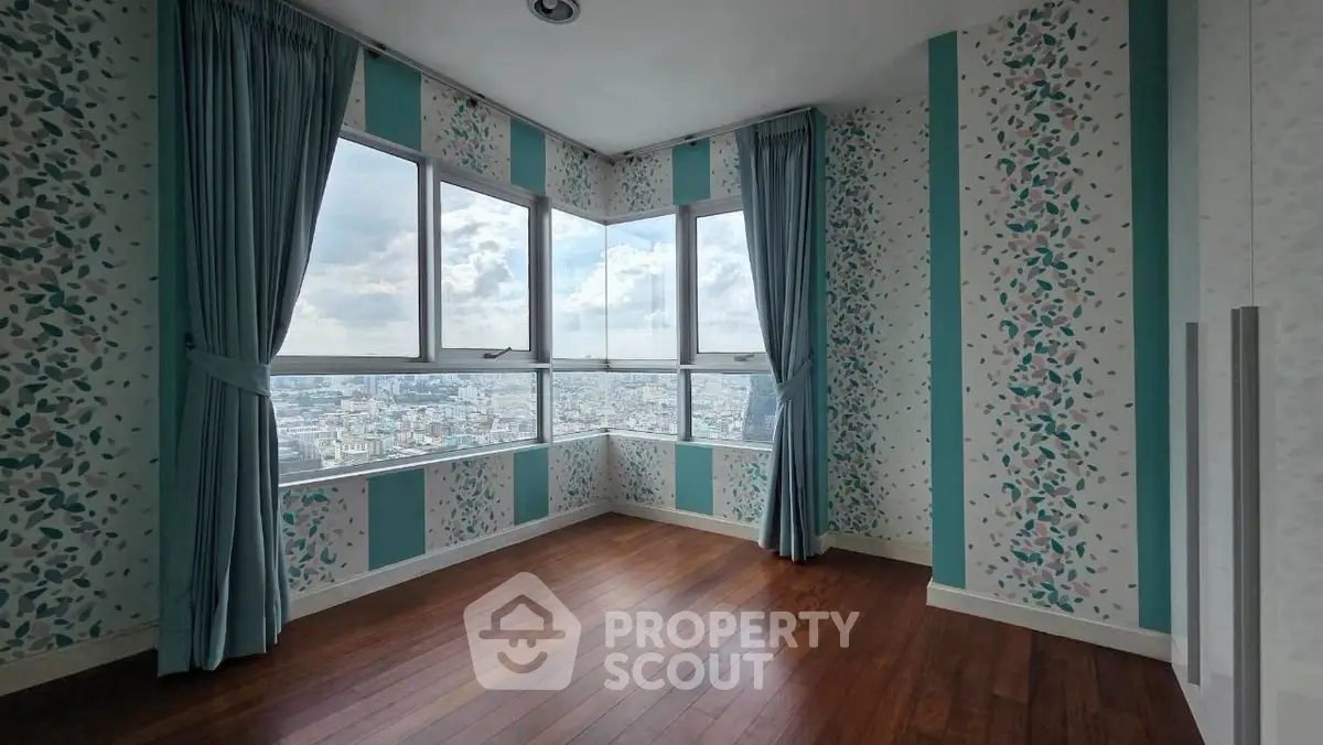 Spacious corner unit with floor-to-ceiling windows offering stunning city views and elegant wood flooring.