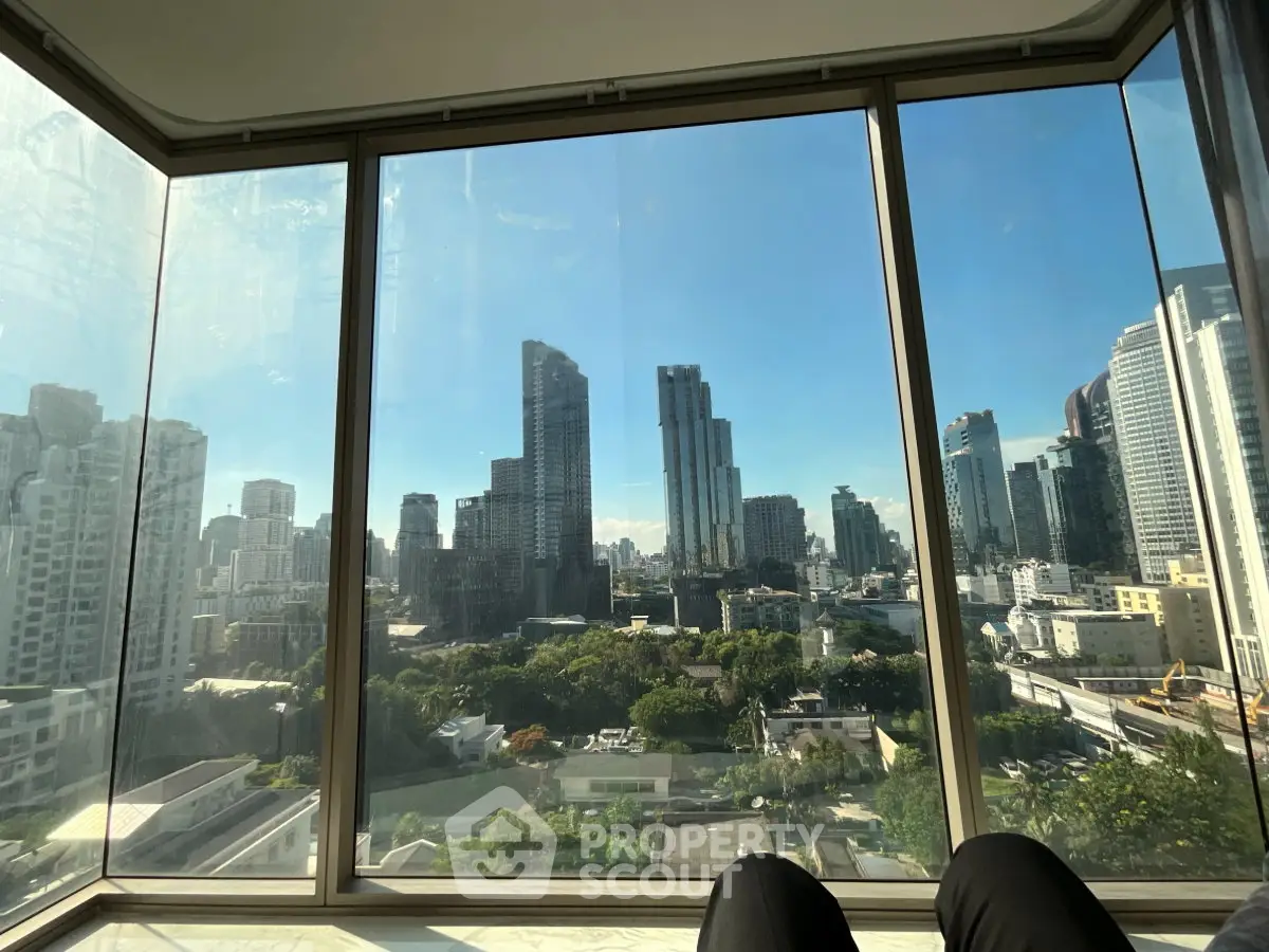 Stunning cityscape view from a modern high-rise apartment with floor-to-ceiling windows.