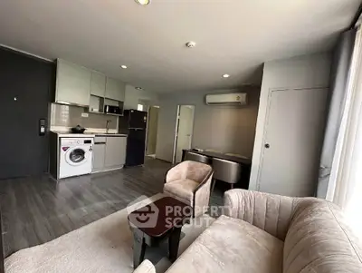 Modern living room with open kitchen, featuring sleek furniture and appliances in a stylish apartment.