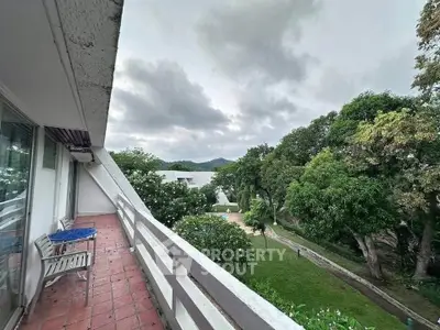 Spacious balcony with scenic garden view in a serene residential area.