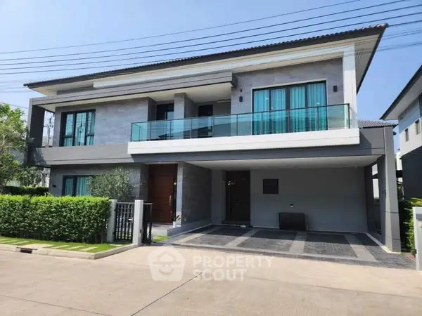 Modern two-story house with glass balcony and spacious driveway