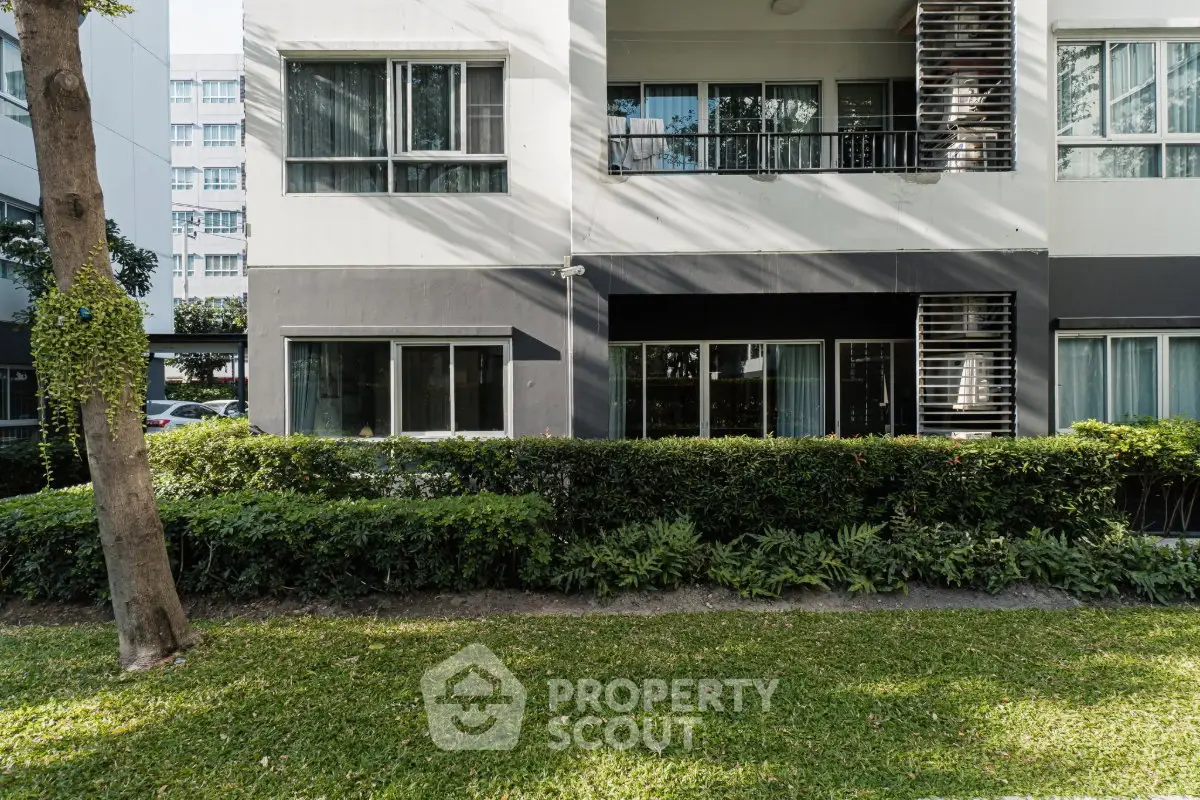 Modern apartment building exterior with lush greenery and large windows