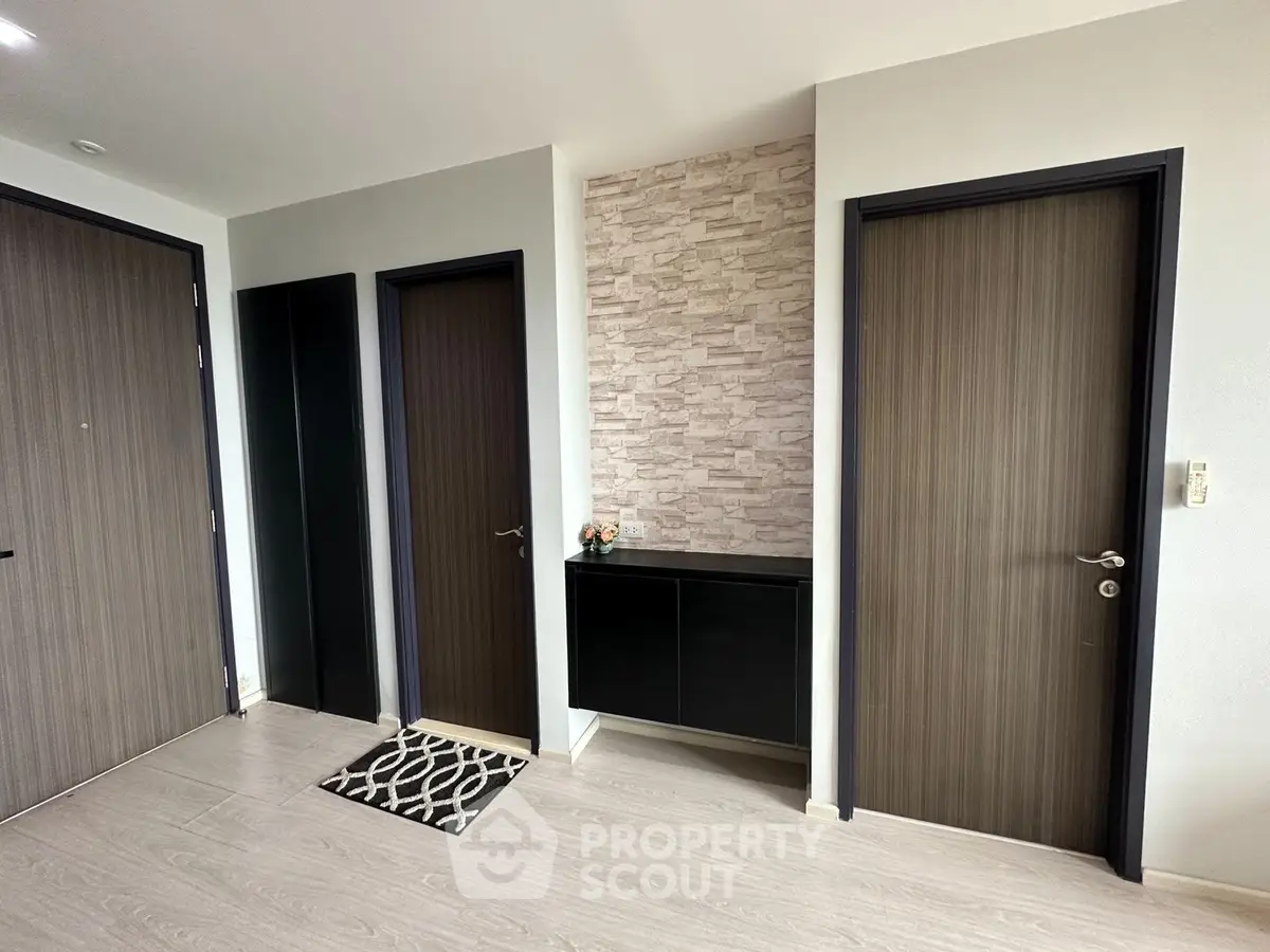 Modern apartment entrance with stylish doors and decorative wall paneling.