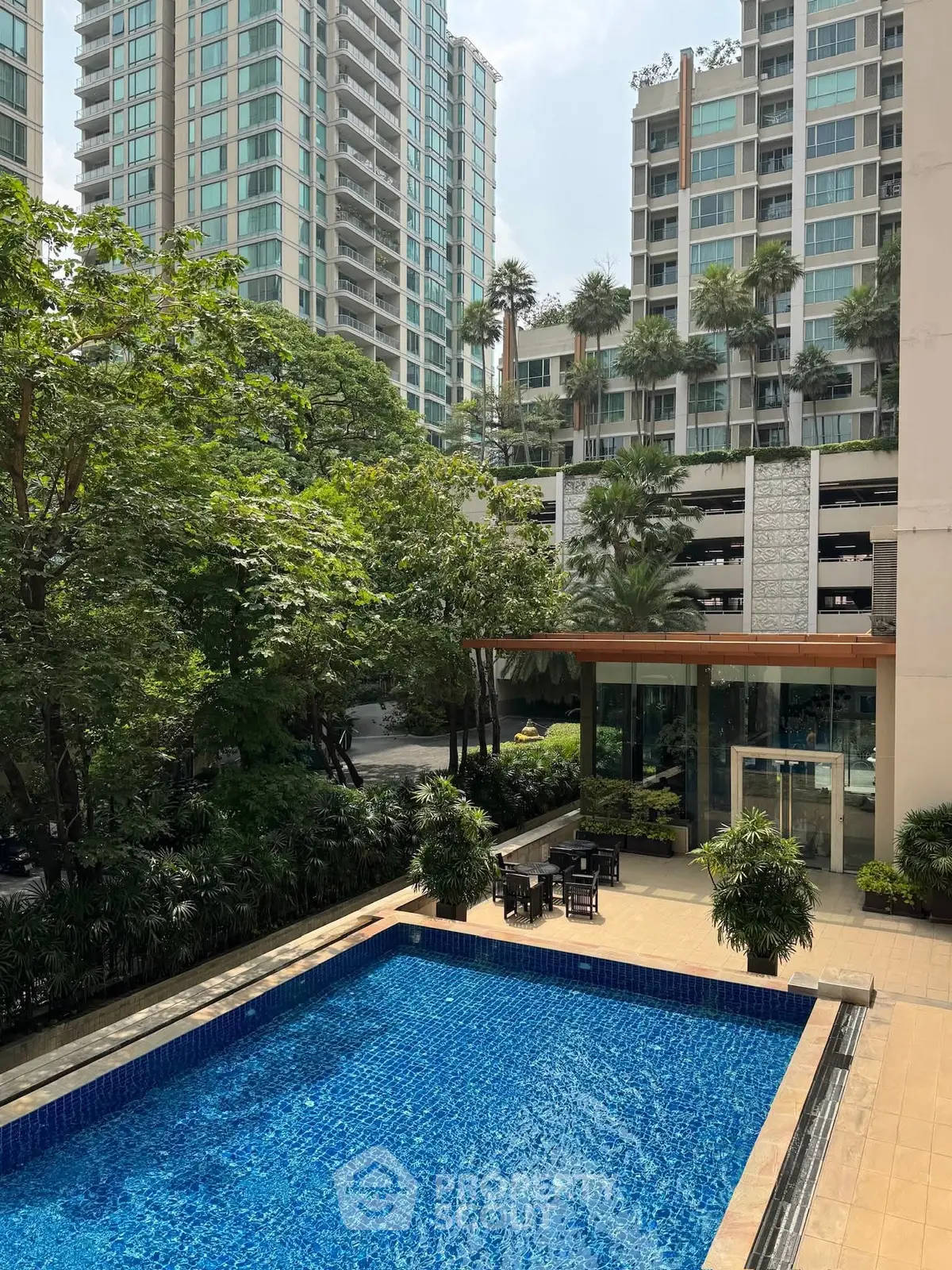 Luxurious apartment complex with a stunning pool and lush greenery.