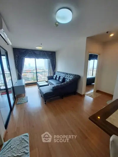 Spacious living room with elegant sofa and balcony view in modern apartment