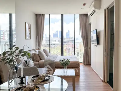 Modern studio apartment with city view, featuring stylish decor and natural light.