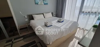 Modern bedroom with natural light, featuring a cozy bed and stylish decor, perfect for relaxation.