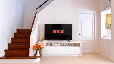 Modern living room with stylish staircase and TV setup, perfect for cozy entertainment evenings.