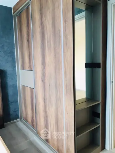 Modern wooden wardrobe with sliding doors and built-in mirror in a stylish interior.